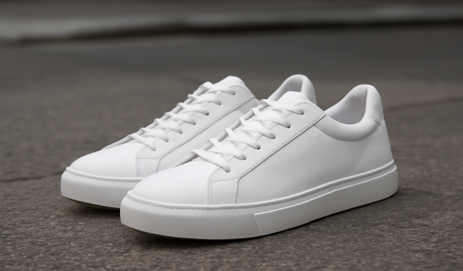 paire de baskets blanches posée sur sol urbain
