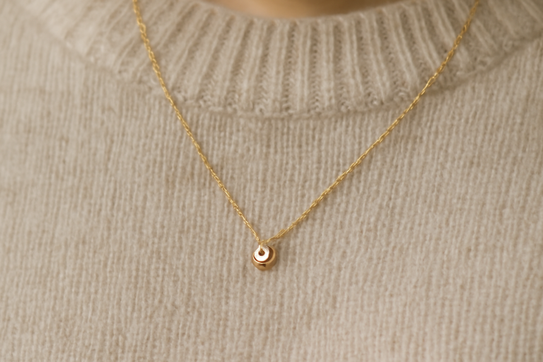 collier delicat pose sur un pull neutre