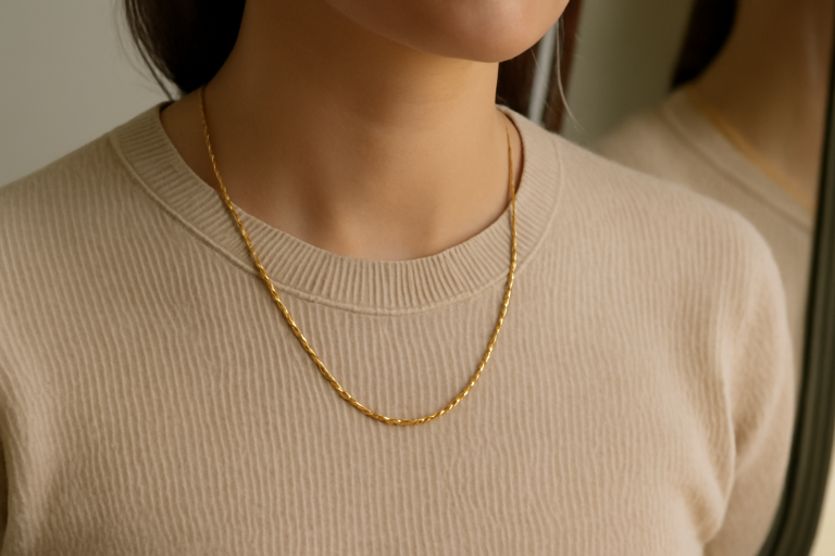 collier porté sur pull uni devant miroir