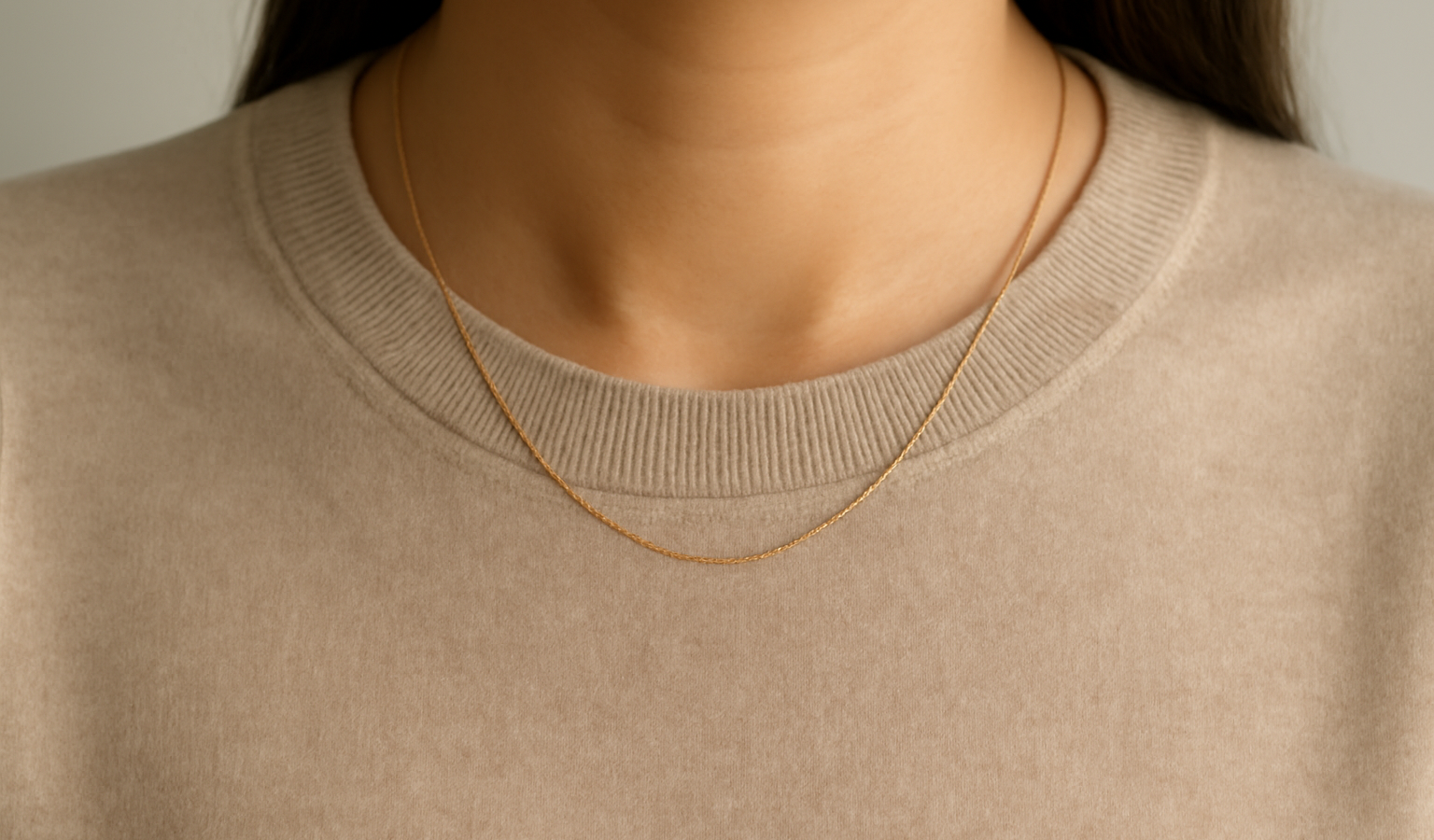 collier discret sur un pull uni